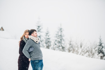 Fototapeta na wymiar Woman leans to her man tender posing in snowy forest