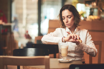 Mixed race woman in coffee shop having coffee and smiling