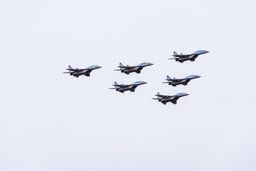 Fototapeta na wymiar Air show in the sky above the Krasnodar airport flight school. Airshow in honor of Defender of the Fatherland. MiG-29 in the sky.