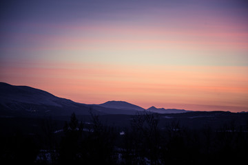 A beautiful, artistic, colorful sunset in Norway above mountains