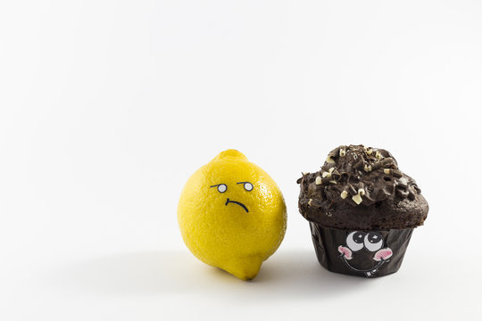 A sweet chocolate muffin and a fresh yellow lemon with cartoon style faces on white background opposing each other