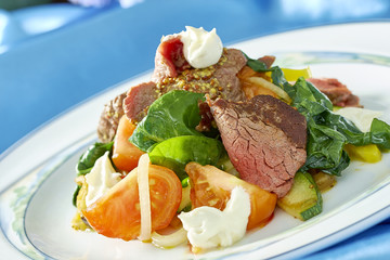 meat salad with green tomatoes on the plate blue background lot of food recipes