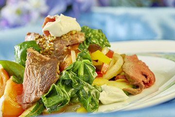 meat salad with green tomatoes on the plate blue background lot of food recipes