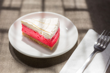 Closeup of a slice of Red Velvet Cheesecake on a white plate