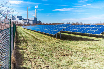 Photovoltaikanlage im Vordergrund und Heizkraftwerk im Hintergrund