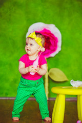 Girl in green pants stands on the floor in green room