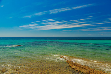 The rocky coast  overlooking the turquoise blue sea in warm summer day.