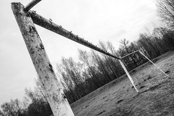 Old and abandoned local soccer stadium - rusty gates / black and white photo 