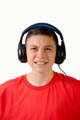 Teenage boy grimacing while listening with headphones