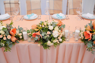 Newlyweds table decorated with bouquet and candles