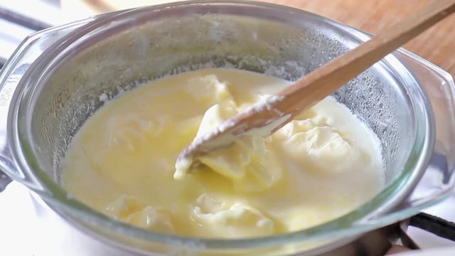 Melting butter by steaming in the glass bowl. Butter being melted in a pot.