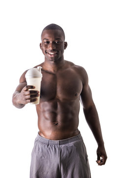 Male black bodybuilder wearing white tanktop on ripped muscular torso in studio shot on black background