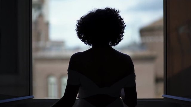 silhouette of sexy dancing woman at the window