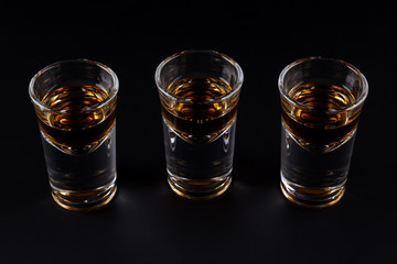 Three shots with cognac or jager on black