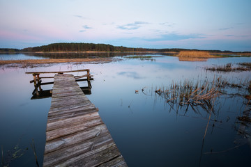 Fototapeta na wymiar Old Wooden pier on the lake. Long exposure.