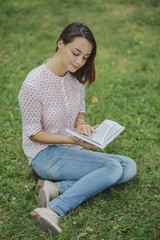 Cute young woman reading the book