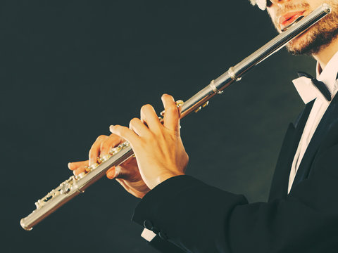 Elegantly dressed male musician playing flute