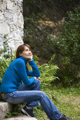 femme paisible assise devant un chalet dans l'herbe