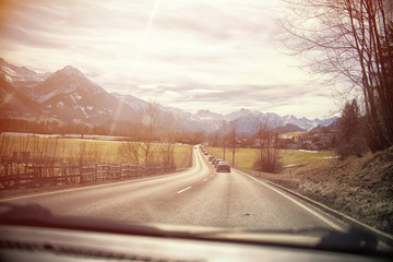 highway in the Alps. view from inside car, sunset or sunrise
