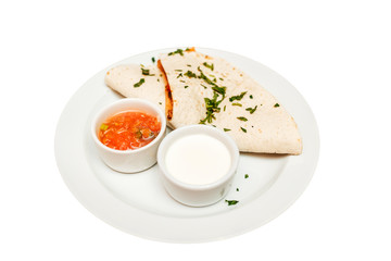 Quesadilla on a plate with sauce isolated