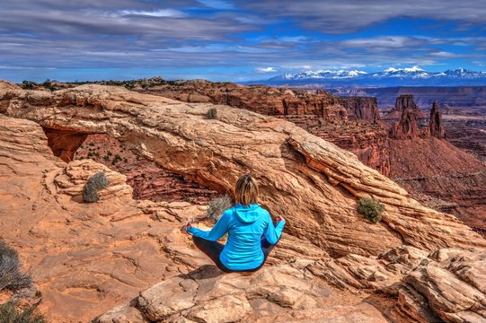 Young Woman Meditating In Desert By Mesa Arch. Canyonlands National Park. Moab. Utah. United States.