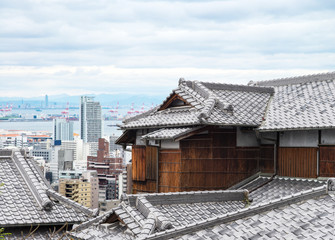 japan wood house with ancient roof and Cityscapes and skyscrapers of Kobe in Fog winter, Skyline of Kobe, office building and downtown of Kobe Bay, Japan,