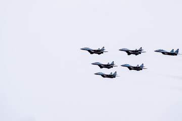 Air show in the sky above the Krasnodar airport flight school. Airshow in honor of Defender of the Fatherland. MiG-29 in the sky.