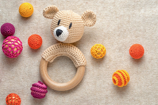 amigurumi toy bear and crocheted beads on a knitted background with copy space