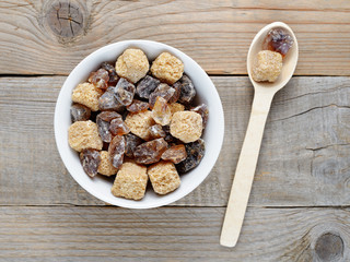 Brown sugar in bowl and spoon on wooden table