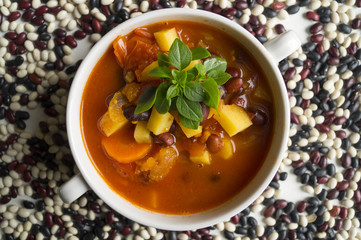 tomato soup with beans on white background.