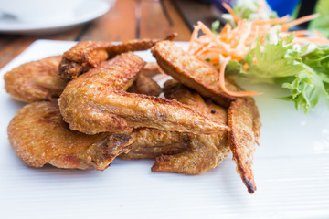 Chichen wing fried with salad in white dish on wooden table with copyspace ,flat lay ,selective focus