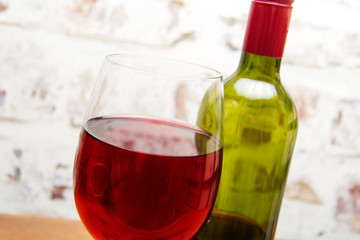 Bottle of red wine with glass ready to pour