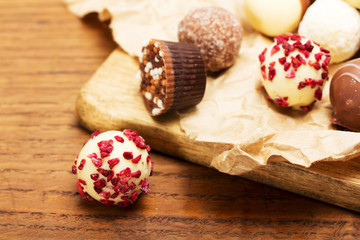 Selection of delicious chocolates on a rustic background