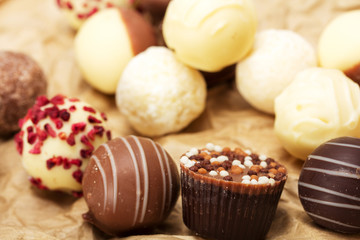 Selection of delicious chocolates on a rustic background