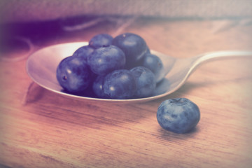 Blueberries and spoon on a rustic background