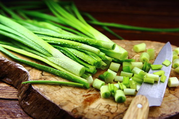 лук зеленый с каплями воды на разделочной доске