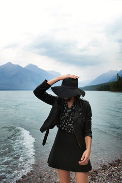 Fashionable woman in hat by lake