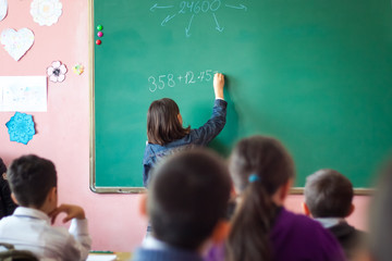 girl resolves mathematical task on board