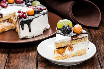 chocolate berry cake slice on plate over brown wooden background
