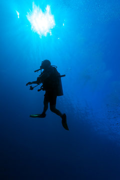 Underwater scene with the silhouette of a scuba diver