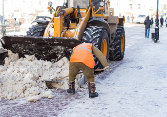 Janitor cleans the street of snow