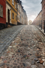 Old picturesque cobblestone street in Stockholm in early morning light.