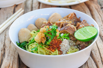 Thai - Chinese style spicy noodle with steamed pork and pork ball served with fresh vegetable and soup