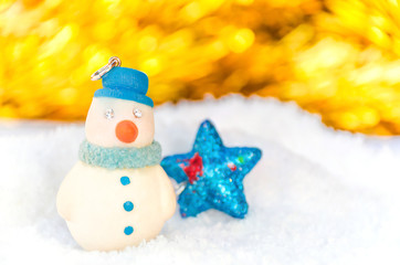 Snow man over blurred shiny yellow strip, blue star and white background for Christmas new year decoration