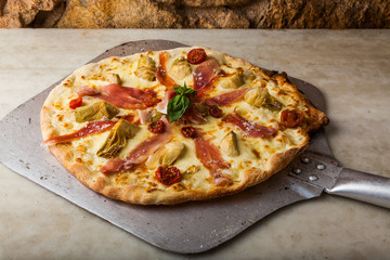 Hot pizza on a paddle, straight from the oven.