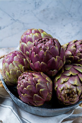 Obraz premium Fresh big Romanesco artichokes green-purple flower heads ready to cook