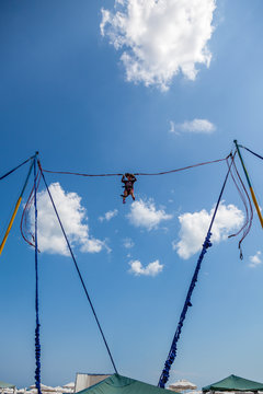 Young girl bungee jump high up in the air with blue sky and clouds. Summer at Sunny beach in Bulgaria.