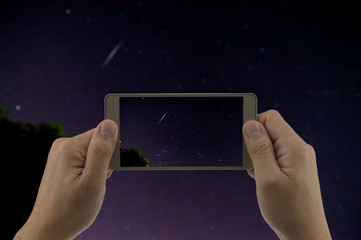 Man is using mobile phone take photo of Geminid meteor, captured at 15DEC2015 12:16AM from flat...