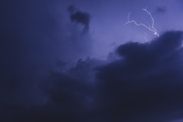 Fototapeta na wymiar Thunderstorm, dark blue three-dimensional clouds illuminated by lightning flashes