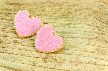 Obraz premium Couple of pink hearts over wooden background